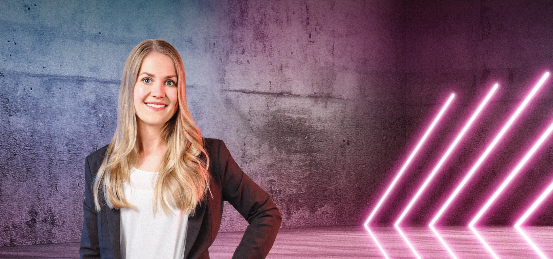Eine Person steht lächelnd vor einer Betonwand mit blau-pinken Lichtverläufen. Rechts im Bild sind mehrere diagonale Neonlichtstreifen zu sehen, die in den Raum weisen. Die Szene wirkt modern und freundlich.