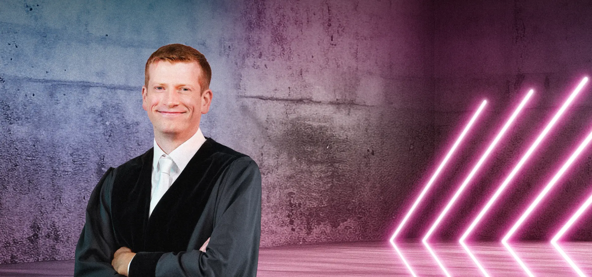 Eine Person in einer Robe steht lächelnd vor einer Betonwand mit farbigem Lichtverlauf in Blau und Pink. Rechts im Bild befinden sich mehrere diagonale Neonlichtstreifen, die in den Raum zeigen. Die Szene wirkt modern und professionell.